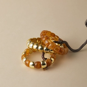 Set di tre braccialetti bohémien con perline dorate e resina ambrata effetto marmo