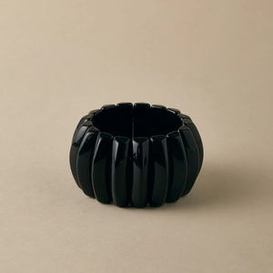 Close-up of a wide glossy black modular resin bracelet with an elastic stretch design