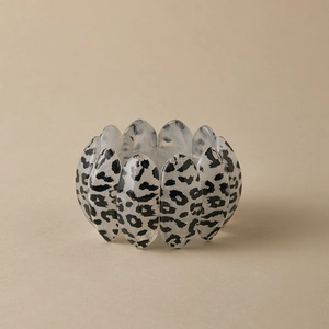 Macro detail of acrylic leopard print bracelet with smooth elastic oval-shaped pieces