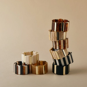 Détail de bracelets extensibles bohèmes avec segments en résine et perles dorées