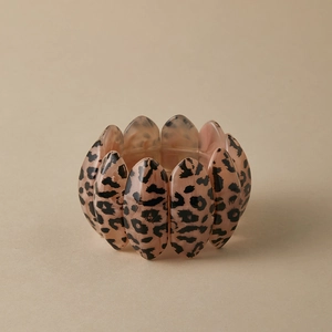Detail of a wide elastic leopard print bracelet featuring pink acrylic resin segments