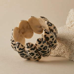 Detail of wide stretch bracelet featuring leopard print and beige marble acrylic beads