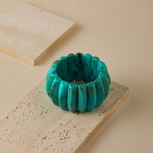 Macro detail of wide beaded bracelet with emerald marble texture and resin segments