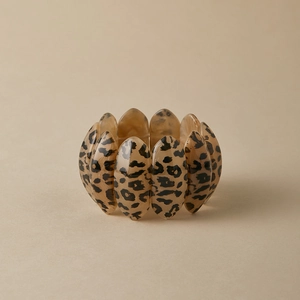 Macro shot of wide leopard print acrylic stretch bracelet with polished amber finish