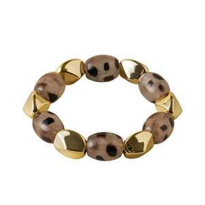 Detail of leopard print resin beads and faceted gold metal spheres on elastic bracelet