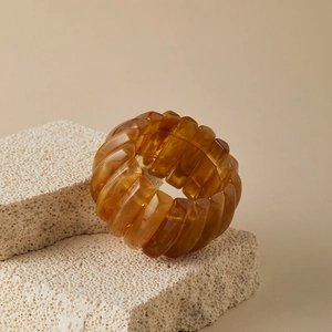 Detail of amber acrylic chunky stretch bracelet displayed on a natural stone prop