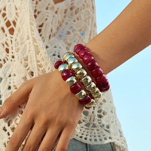 Set di tre braccialetti bohémien con perline rosse e dorate indossati da una modella
