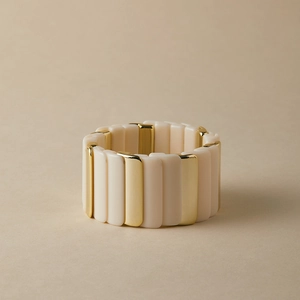 Détail d'un bracelet bohème extensible avec blocs de résine crème et métal doré