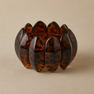 Macro shot of polished wide leopard print acrylic bracelet with tortoise shell texture