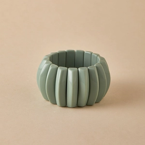 Close-up of sage green beaded acrylic stretch bracelet with polished marble texture