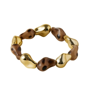 Detail of leopard print resin beads and gold-tone metal accents on a stylish chunky bracelet