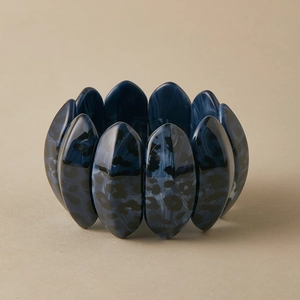 Macro view of wide leopard print acrylic bracelet with blue marble texture detail