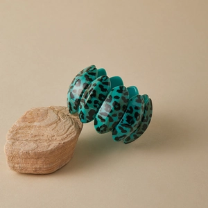 Detailed view of turquoise leopard print acrylic chunky elastic bracelet on stone base