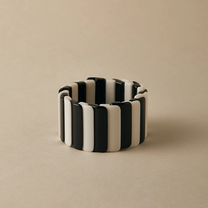 Détail de bracelet élastique en résine noire et blanche avec finition brillante