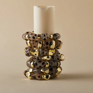 Stacked leopard print resin bracelets with irregular gold metal accents on beige rolls