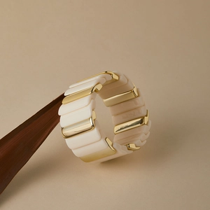 Détail d'un bracelet bohème extensible avec blocs de résine crème et accents dorés