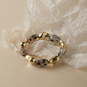 Close-up of chunky irregular gold beads and marble textured resin beads on a stylish bracelet