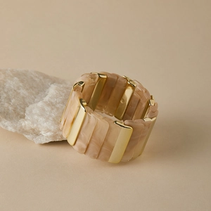 Détail d'un large bracelet jonc avec segments en résine marbrée et accents en métal doré