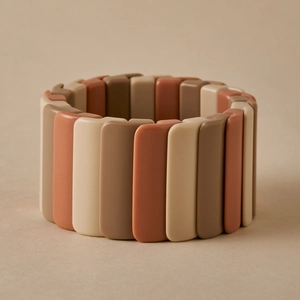 Détail du bracelet extensible large avec tuiles en résine marbrée aux tons de terre