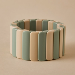 Détail d'un bracelet extensible large avec blocs de résine beiges et verts irréguliers