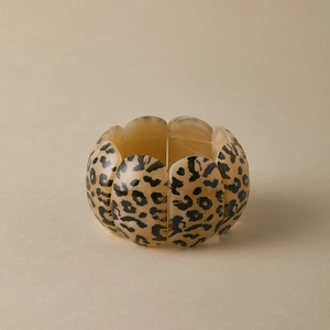 Detail of a vintage leopard print stretch bracelet with amber resin segments