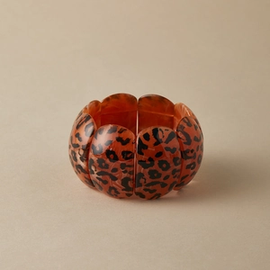 Detailed view of the wide leopard print resin bracelet with elastic segments and glossy finish