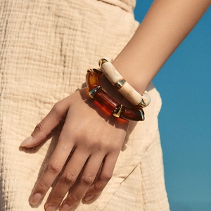 Bohemian acryl armbandenset met amber- en marmertextuur om de pols van een model