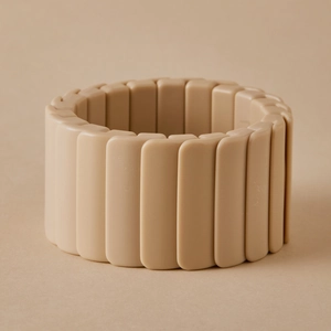 Détail d'un large bracelet élastique aux blocs de résine beige de style mosaïque