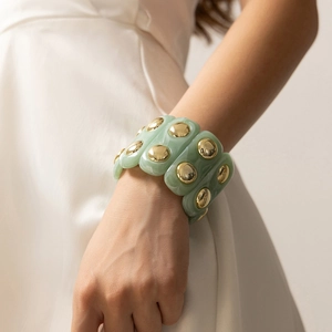 Bracciale boho in resina verde menta marmorizzata con dettagli dorati su una modella