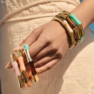 Bracelet jonc chic en acrylique bambou avec segments dorés porté par un mannequin