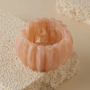 Détail du bracelet en résine rose marbrée montrant la structure élastique large
