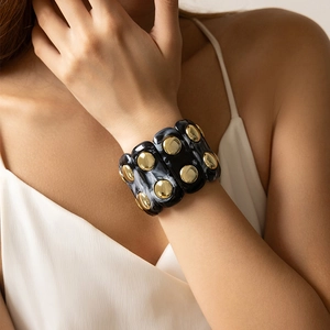 Bracciale elastico bohémien in acrilico marmorizzato nero con borchie dorate