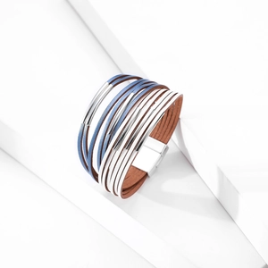 Détail d'un bracelet multicouche en cuir bohème avec fermoir magnétique et touches bleues