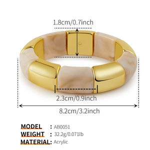 Macro-opname van beige marmeren acryl bangle met getextureerde gouden metalen
