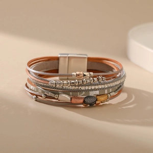 Détail du bracelet multicouche en cuir bohème avec feuilles en métal et fermoir aimanté