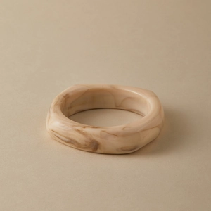 Macro detail of glossy milk white and brown marble texture on acrylic resin thick bangle