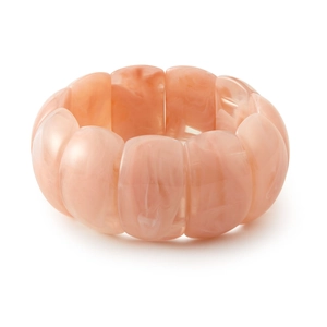 Détail du bracelet en résine rose clair montrant la texture marbrée et les perles
