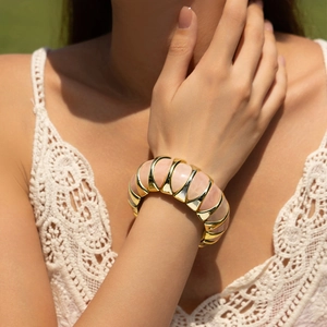 Bracelet vintage en résine rose avec design modulaire en métal doré sur le poignet
