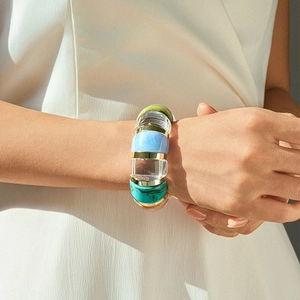 Detail of colorful acrylic resin bead bracelet with gold metal rings on female wrist