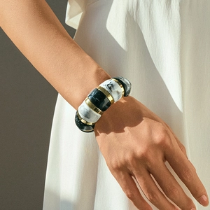 Close-up of bohemian chunky acrylic bracelet with marble texture and gold metal spacers