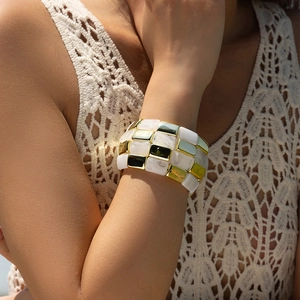 Wide chunky bracelet with gold metal blocks and white marble resin on a female wrist