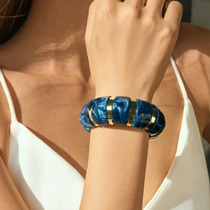 Close-up of bohemian blue marble acrylic bracelet with gold metal spacer accents