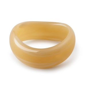 Macro view of polished wide acrylic bangle with amber-toned translucent marble texture