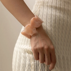 Bracciale largo in resina acrilica rosa marmorizzata indossato da una modella