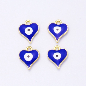 Detalle de cuatro dijes de corazón ojo turco azul con borde dorado para joyería