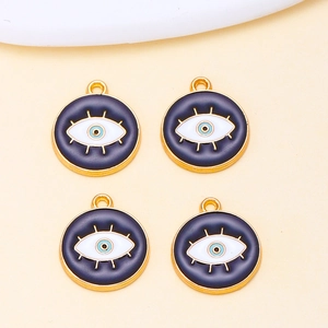 Detail of four blue evil eye alloy pendants with gold lashes for DIY jewelry making