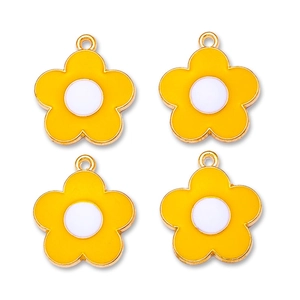 Macro view of four yellow and white alloy flower pendants for DIY jewelry making