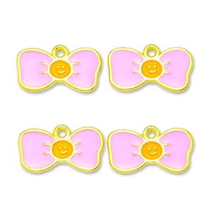 Close-up of pink enamel bow charms with yellow smiley faces for DIY jewelry making