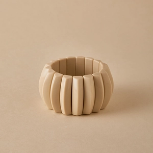 Primer plano de pulsera elástica de resina beige con cuentas geométricas rectangulares