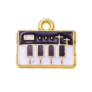 Macro detail of alloy piano key pendant with black and white enamel and gold plating